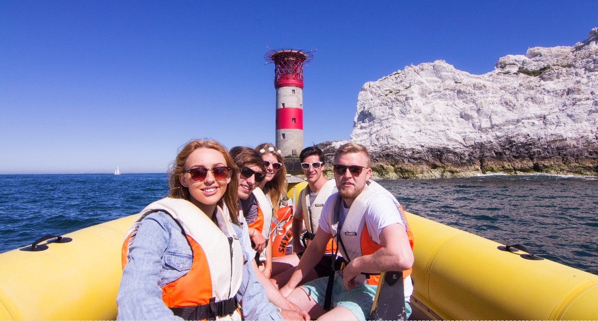 Group sitting on boat with the Needles in background