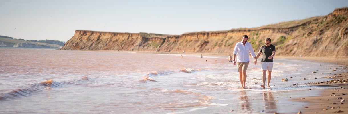 Couple walking along beach at Brook, Isle of Wight