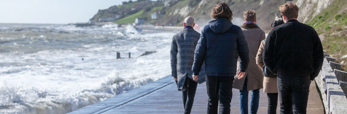 Group walking along the sea wall at Ventnor, Isle of Wight