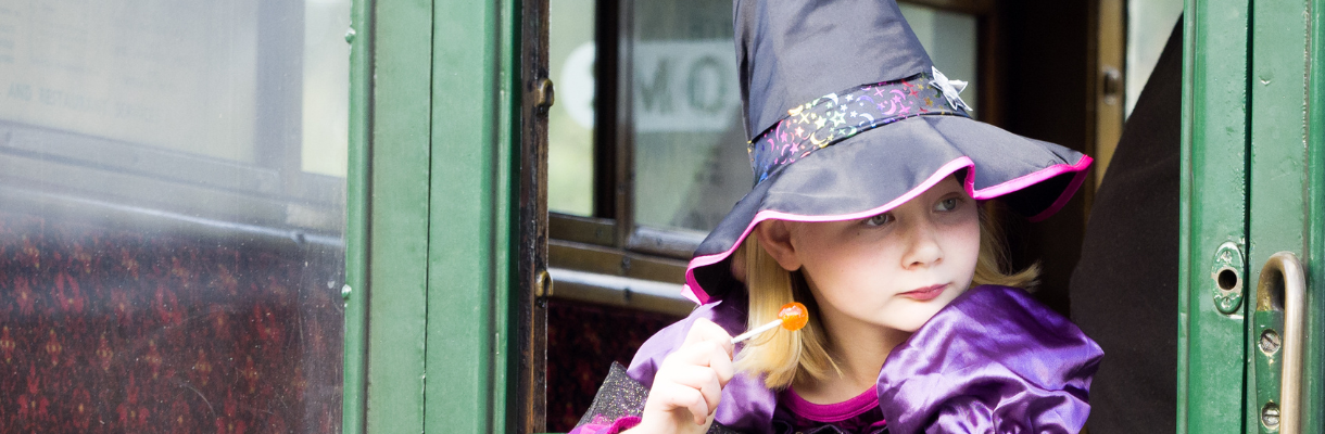 Girl dressed up as a witch looking out of the window of the carriage, Isle of Wight Steam Railway