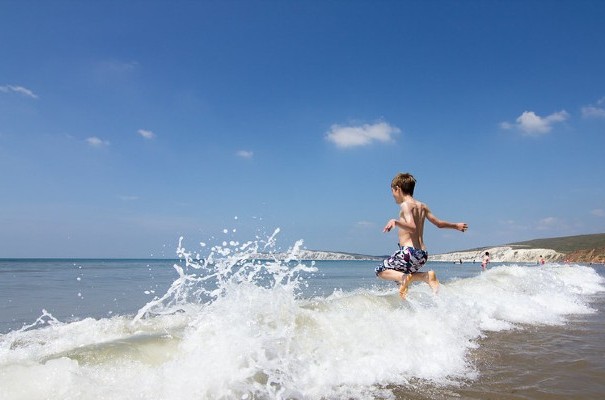 Boy jumping waves at Compton beach