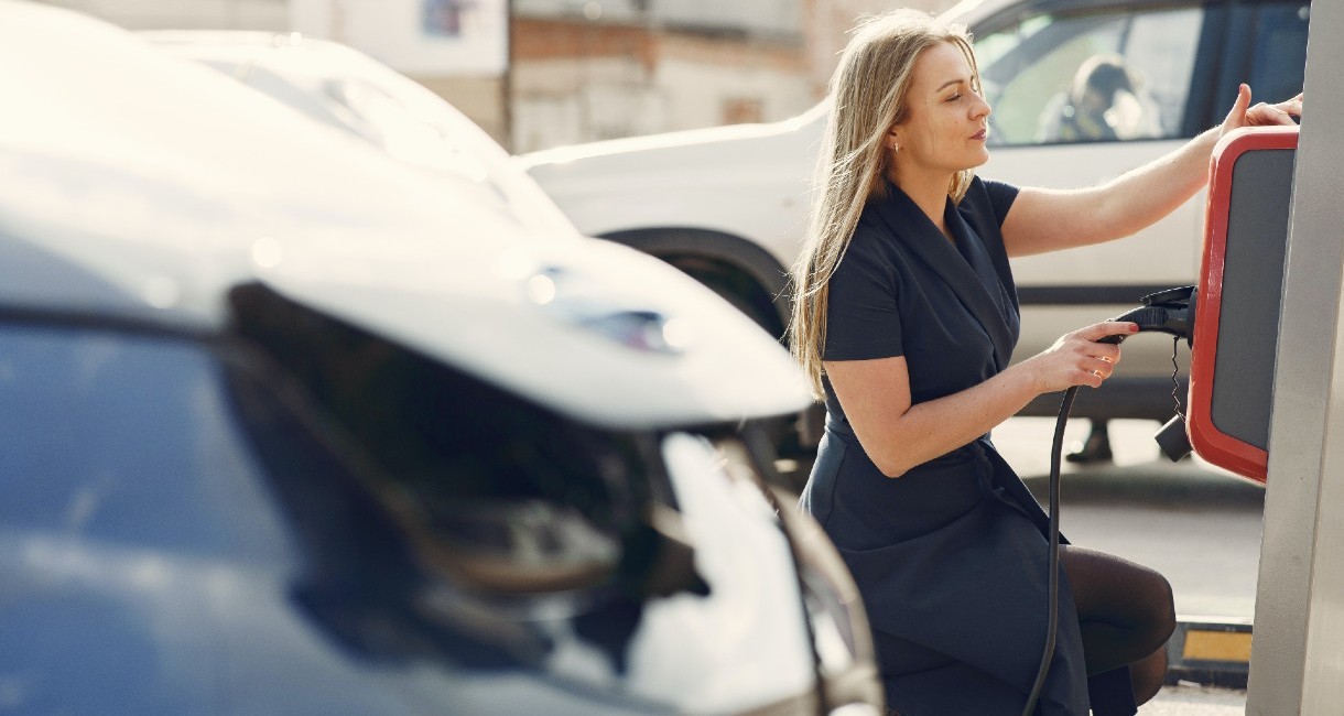 Lady charging electric vehicle