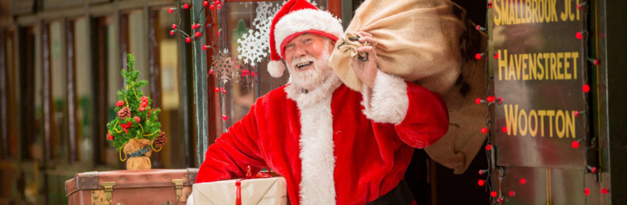 Santa with presents on the platform with the steam train stationed in the background, Isle of Wight Steam Railway